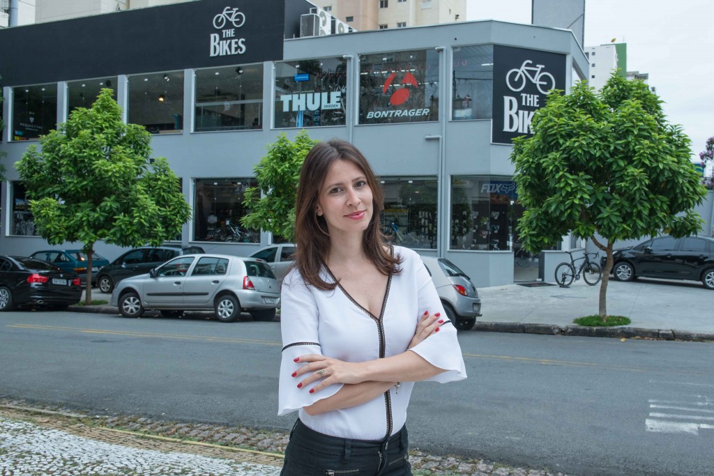 A curadora Lívia Doblas, em frente à loja onde acontecerá a exposição (Foto Divulgação) 